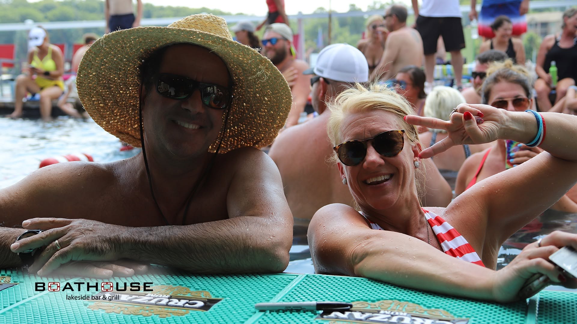 A smiling couple at the Boathouse swim-up bar