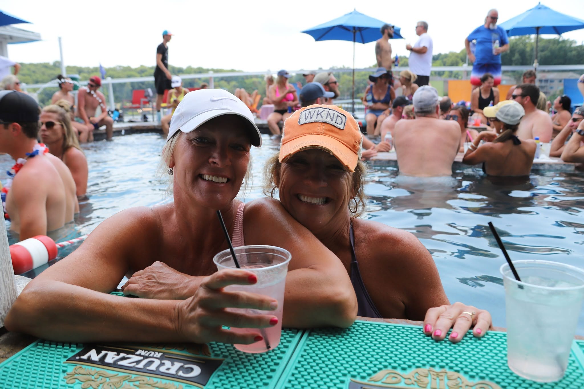 Two friends enjoying drinks at the Boathouse swim-up bar