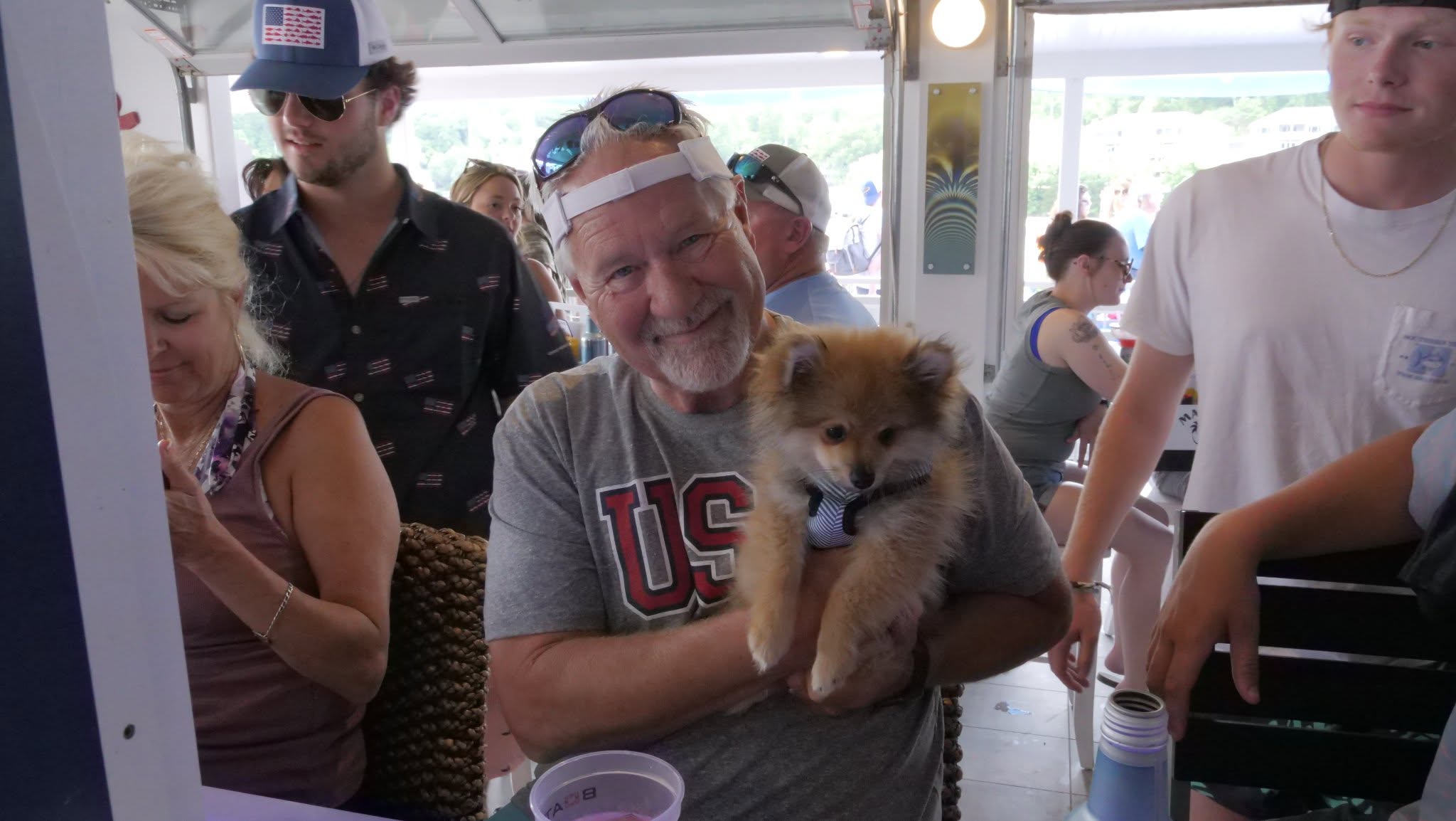 A guest holding a Pomeranian inside Boathouse