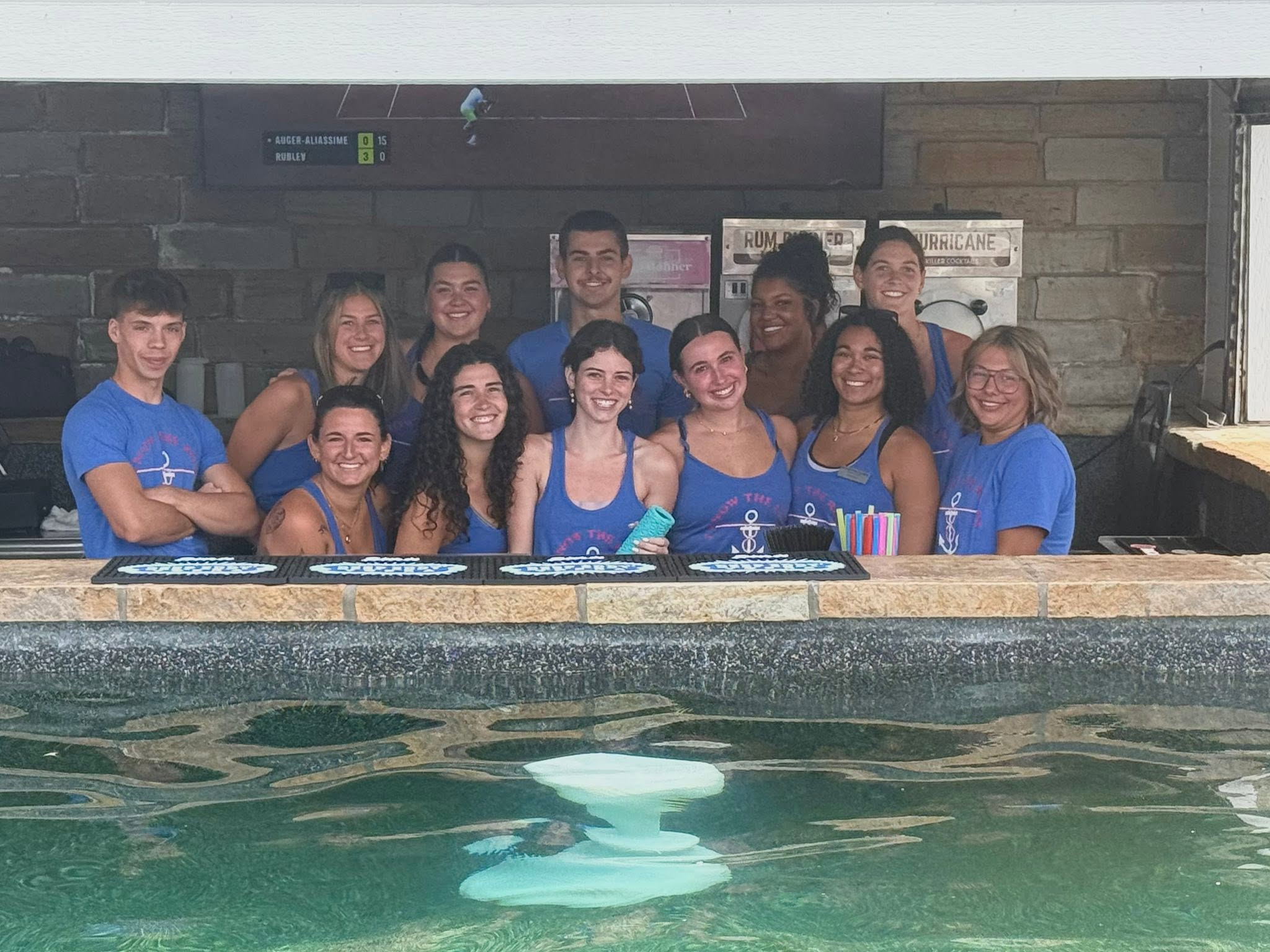 The Boathouse team smiling behind the swim-up bar